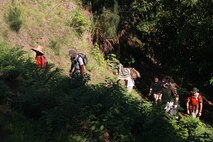 The Marine Forces Pacific Defense Policy Review Initiative Pagan Survey team observes terrain and tracks routes with global positioning systems while hiking during a Technical Survey, Pagan, July 30, 2013.  Team members plot points and routes of existing roadways, historical markers to enhance and refine existing maps.