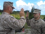 SSgt Alex Polley swears in with Marine Corps Activity Guam Officer in Charge Colonel Scott Loch during his reenlistment.