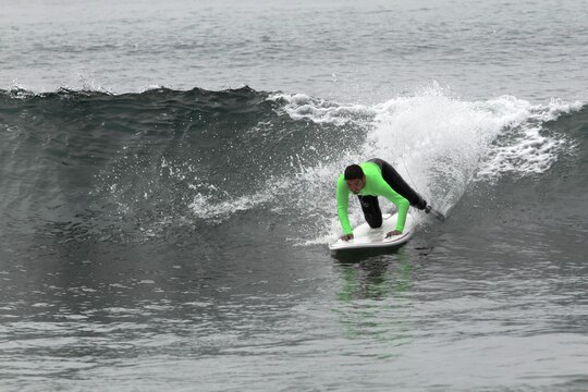 Cpl. Carlos Torres, a double amputee, attempts to stand as he catches a wave during the Operation Amped surf clinic at the San Onofre beach here Aug. 24. During the 3-day surf camp, veterans learned to surf and built comradery with each other and the surf community.