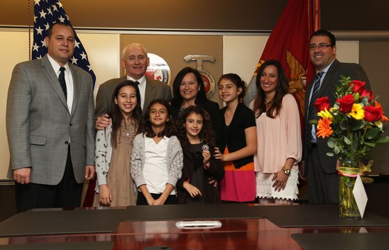 G-1 Assistant Chief of Staff for Marine Corps Installations West-Marine Corps Base Camp Pendleton, Thomas K. Farrell, poses for a picture with friends and family at an award ceremony at Camp Pendleton, Calif., Feb. 1. Farrell was awarded the Commendation for Superior Civilian Service for his superior performance.
