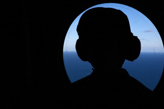 A Marine with Marine Medium Helicopter Training Squadron 164 'Knight Riders' sits in front of a window inside a CH-46 Sea Knight during a pre-graduation flight just outside Marine Corps Air Station Camp Pendleton, Calif., Feb. 20. After this graduation, the Marine Corps will no longer train crew chiefs on the CH-46 Sea Knight as it is transitioned out of the Marine Corps.