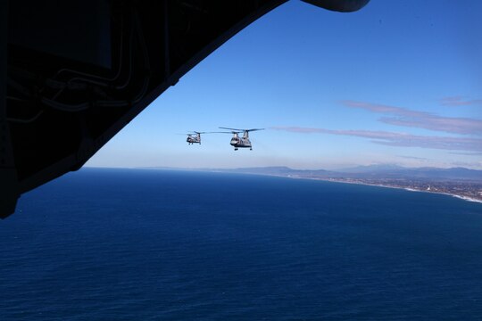 Two CH-46 Sea Knights fly over the ocean just outside Marine Corps Air Station Camp Pendleton, Calif., Feb. 20. Inside the hulls of these aircraft eight Marines took their last flight as students before graduating as Sea Knight crew chiefs later that day.
