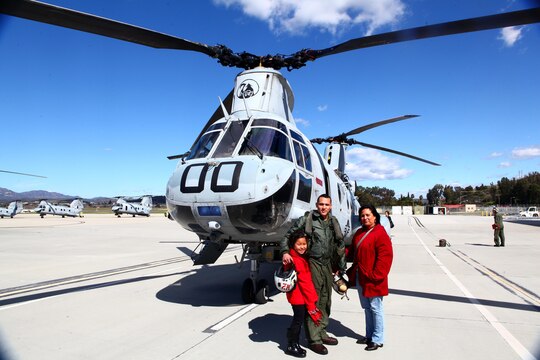 Lance Cpl. Alex Sosa III, center, the CH-46 Sea Knight crew chief honor graduate with Marine Medium Helicopter Training Squadron 164 and a Richmond, Texas, native, poses with his mother and little sister in front of a Sea Knight on the flight line aboard Marine Corps Air Station Camp Pendleton, Calif., Feb. 20. As the Sea Knight is phased out of the Marine Corps, Sosa and his peers were the last to be designated as CH-46 crew chiefs.