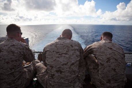 Marines with the 31st Marine Expeditionary Unit sit on the edge of the flight deck and enjoy their barbeque during a steel beach picnic to celebrate Independence Day here, July 4. The “blue and green” team grilled more than 1,300 burgers, 800 pieces of chicken and 800 hotdogs to give the Marines and Sailors a taste of home during the  holiday celebration. The 31st MEU is the only continuously forward deployed MEU and is the Marine Corps’ force in readiness in the Asia-Pacific region.