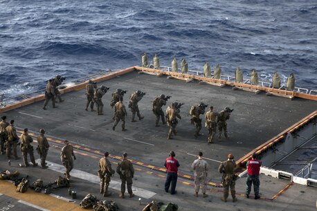 Marines and Sailors of the Force Reconnaissance Platoon, 31st Marine Expeditionary Unit, engage targets on the port side elevator of the ship here, July 7. The group used M4 carbines and M45 pistols to hone their skills in close combat marksmanship. The 31st MEU is the Marine Corps’ force in readiness for the Asia Pacific region and the only continuously forward-deployed MEU. 