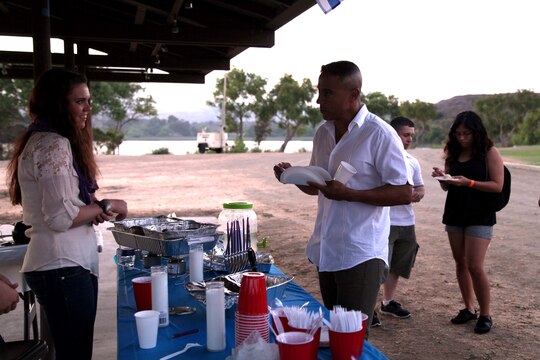 Col. Michael R. Cordero speaks to Lance Cpl. Dana Perkinsgoodrie during the International Evening Under the Stars July 12 at the Lake O'Neil Peninsula, here. "We brought the best of all the cultures into one place and we live in tolerance and respect of those different cultures," said Cordero. "The diversity we have here today as you look around is what makes our great country that much greater." Cordero is the commanding officer of Headquarters and Support Battalion.