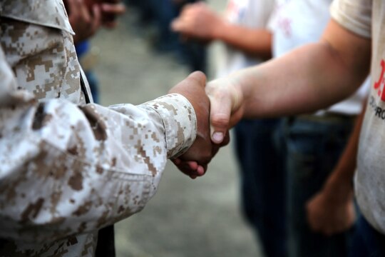 A Devil Pup shakes hands with his instructor during the challenge coin ceremony atop of the Alpha shelf after climbing Old Smokey here July 11. The challenge coin ceremony takes place immediately after the Devil Pups climb to the top of Old Smokey, completing their training. Devil Pups Inc. encampments are a ten-day youth camp that teaches discipline and respect to teenagers age 14-17.

