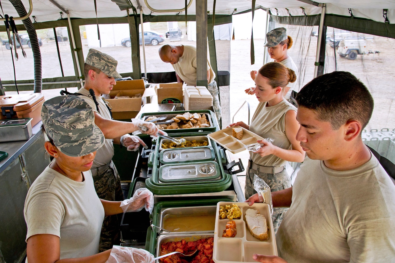 Airmen serve dinner in the field in a mobile kitchen trailer during Global Medic 13 on Fort McCoy, Wis., July 16, 2013. The food service specialists are assigned to the 940th Force Support Squadron, Beale Air Force Base, Calif.