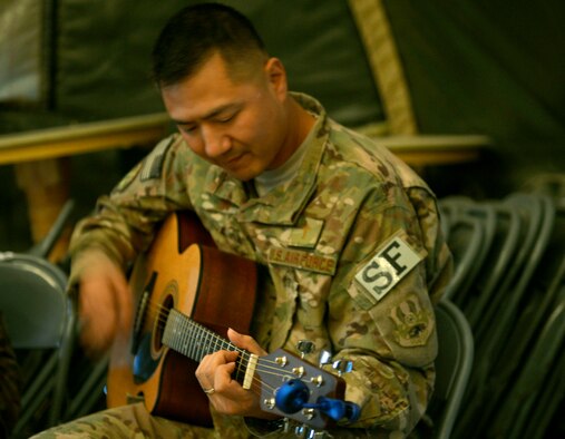 Chaplain (Capt.) Myung Cho and his assistant Staff Sgt. Frank Rivas, play the guitars and sing a song during a worship service with Airmen assigned to the 455th Expeditionary Security Forces Group at Bagram Air Field, Afghanistan, July 21. Cho visits the airmen prior and during their shifts as much as he can to raise their morale and offer a variety of worship services. ( U.S. Air Force photo/ Staff Sgt. Stephenie Wade) 

