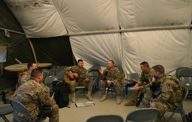 Chaplain (Capt.) Myung Cho and his assistant Staff Sgt. Frank Rivas, play the guitars and sing a song during a worship service with Airmen assigned to the 455th Expeditionary Security Forces Group at Bagram Air Field, Afghanistan, July 21. Cho visits the Airmen prior and during their shifts as much as he can to raise their morale and offer a variety of worship services. ( U.S. Air Force photo/ Staff Sgt. Stephenie Wade)