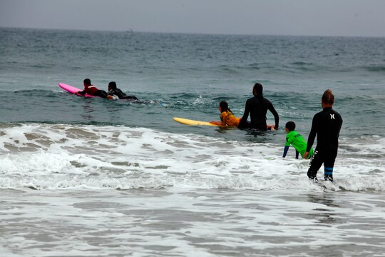 Children surf with the help of some of Hurley’s profession surf team riders during the Hurley surf event held at Del Mar Beach Resort here June 2. Hurley’s summer surf tour travels around the country to let young kids learn from and ride with professional surfers.