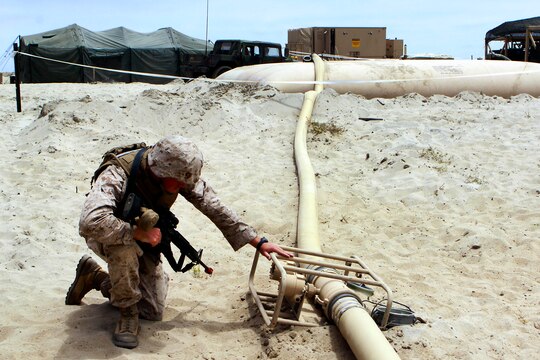 Lance Cpl. Francis King checks a monitor on the pipeline to make sure the right number of gallons flow through per hour on the Army side of the line during the Quartermaster Liquid Logistics Exercise held here June 6. The Quartermaster Liquid Logistics Exercise is an Army reserve exercise that helps train service members in the movement of large amount of fuels from one fuel farm to another. King is a bulk fuel specialist with Bulk Fuel Company A, stationed in Tucson, Ariz.