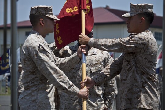 Maj. Andres H. Caceres-Solari, right, outgoing Combat Logistics Company 36 commanding officer, passes the CLC-36 guidon to Capt. Charles R. Johnston, incoming CLC-36 commanding officer, during the CLC-36 change-of-command ceremony, which took place outside the CLC-36 building, June 13, 2013. Along with the change-of-command ceremony, Caceras-Solari received the Meritorious Service Medal and the Outstanding Volunteer Service Medal.