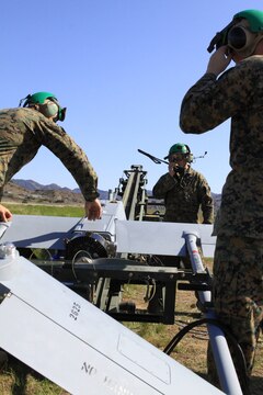 Cpl. Andrew Smith, left, Sgt. Derrick Williams, center, Sgt. Michael Lomartire, right; prepare the RQ-7B Shadow, an unmanned aerial vehicle, for a launch conducted here, Feb. 27.
Williams was the plane captain and quality assurance chief for this exercise, and all of the Marines are UAV technicians from Marine Unmanned Vehicle Squadron 3 and VMU-4.
