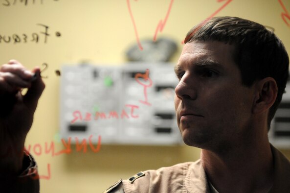 Capt. Brandon Davenport diagrams how to geolocate a jamming signal Feb. 28, 2013, at a deployed location in Southwest Asia. Davenport is the U.S. Air Forces Central Command Combined Air and Space Operations Center Combat Operations Division Space Cell chief. Jamming is the denial, whether intentional or accidental, of a satellite's ability to communicate by overwhelming it with another signal. Geolocating allows coalition forces to reliably attribute the source of the jamming signal and help prevent it from happening again. (U.S. Air Force photo/Tech. Sgt. Mike Andriacco)