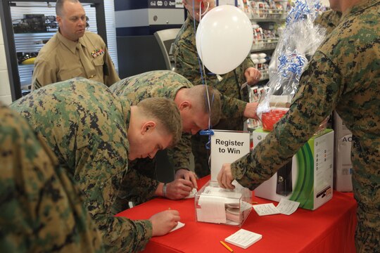Marine Corps Special Operations Command Marines fill out registration cards to participate in a raffle held at the grand opening of the new Marine Corps Exchange aboard Stone Bay on Feb. 22. A television and game system were among other items at the raffle available to win.