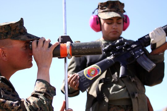 Sgt. Shayne Whitaker, left, reviews shot points for his teammate Cpl. Raquel Martinez while she waits on the firing line to continue shooting during the Western Division Matches held at Wilcox Range here March 6. 

Whitaker is a block noncommissioned officer for Edson Range with Marine Corps Recruit Depot and Martinez is a range coach with MCRD. 
 
