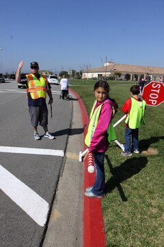 Christina Candia, a 10-year-old fifth grader of North Terrace Elementary School, holds the "candy cane" pole to prevent students from running across the street before the traffic was stopped. The supervising faculty used whistles and hand gestures to signal traffic in the intersection.