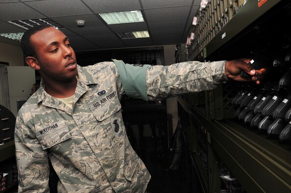 U.S. Air Force Airman 1st Class Michael McKeithan, 380th Expeditionary Security Forces Squadron armorer, pulls an M9 pistol from its storage location to issue it to another 380 ESFS Airmen April 30, 2013. The armory here stores weapons, ammunition, radios and more to ensure the Airmen have the tools necessary to defend the base on a daily basis. McKeithan is deployed here from Laughlin Air Force Base, Texas, and is a native of Petersburg, Va. (U.S. Air Force photo by Staff Sgt. Timothy Boyer)  