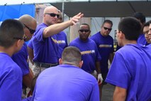 Colonel Scott Loch speaks to volunteers before moving out on the tarmac to pull the plane which Marine Corps Activity Guam and friends participated in the United Plane Pull sponsored by the Onedera retail store. The plane pull had many prizes to give and was divided between co-ed and mens teams, with an optional truck-pull to the participating teams.