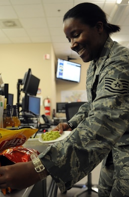 Tech Sgt. Teresa Burger, Air Force Central Command logistics planner, grabs chips to accompany some guacamole May 3 at an undisclosed location in Southwest Asia. Burger is deployed from Moron Air Base, Spain. (U.S. Air Force photo by Staff Sgt. Rachelle Elsea) 
