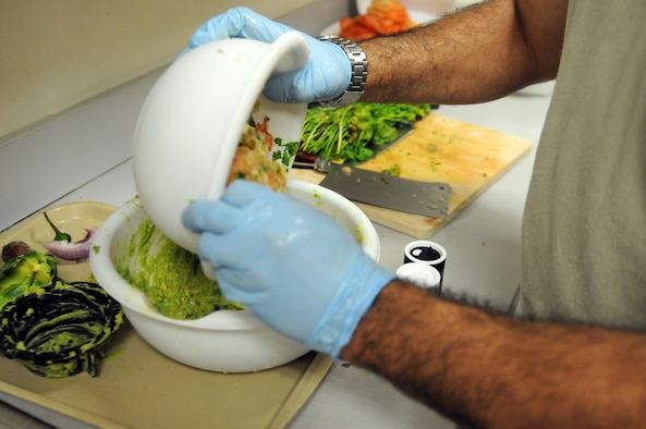 Master Sgt. John P. Garcia Jr, Air Forces Central Command vehicle fleet manager, mixes freshly-made Pico de Gallo with smashed avocados to create guacamole. (U.S. Air Force photo by Staff Sgt. Rachelle Elsea) 

