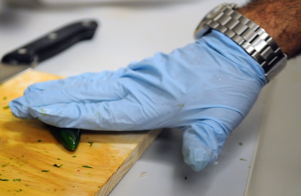 Master Sgt. John P. Garcia Jr, Air Forces Central Command vehicle fleet manager, and native of Los Angeles, Calif., rolls a jalepeno under his hand May 3 at an undisclosed location in Southwest Asia. This breaks up the veins inside and releases moisture to create a spicier jalapeno. (U.S. Air Force photo by Staff Sgt. Rachelle Elsea) 


