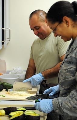 Master Sgt. John P. Garcia Jr, Air Forces Central Command vehicle fleet manager, and Tech. Sgt. Mishal Crane, Combined Air and Space Operations Center NCO in charge of commander support staff, prepare ingredients for guacamole May 3 at an undisclosed location in Southwest Asia. (U.S. Air Force photo by Staff Sgt. Rachelle Elsea) 

