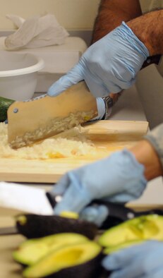 Master Sgt. John P. Garcia Jr, Air Forces Central Command vehicle fleet manager, and Tech. Sgt. Mishal Crane, Combined Air and Space Operations Center NCO in charge of commander support staff, prepare ingredients for guacamole May 3 at an undisclosed location in Southwest Asia. (U.S. Air Force photo by Staff Sgt. Rachelle Elsea) 

