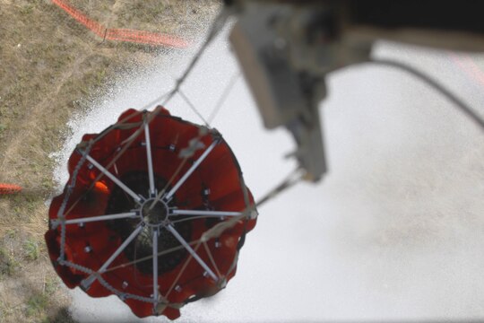 A Bambi Bucket, also known as a fire bucket, is attached to a CH-46E drops water over a target during the 6th annual aerial wildland fire fighting exercise here May 9.  