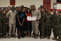 GySgt Jaime Hernandez, with Marine Corps Activity Guam, poses with his family during his reenlistment ceremony at the Okkado High School with the Marine Corps Junior Reserve Officer Training Corps, 13 May, 2013. 