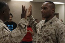 GySgt Jaime Hernandez, with Marine Corps Activity Guam, right, recites the oath of enlistment during his reenlistment ceremony at the Okkado High School with the Marine Corps Junior Reserve Officer Training Corps. 