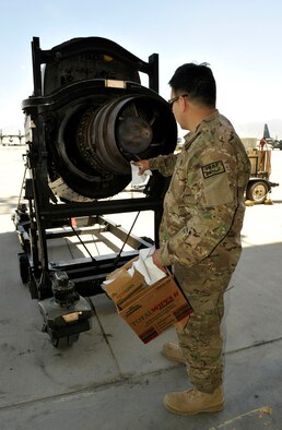 Staff Sgt. Christopher Contreras, 455th Aircraft Maintenance Squadron C-130 maintainer, cleans dirt and water out of an engine, prior to a customs inspection on Bagram Airfield, Afghanistan, May 13, 2013. The engine must be clean of dirt, water, insects and vegetation prior to customs approving it for shipment. Contreras is deployed from Little Rock Air Force Base, Ark. (U.S. Air Force photo/Staff Sgt. Stephenie Wade)