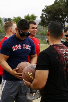 A Marine from Headquarters and Headquarters Squadron prepares himself to shoot a free throw while wearing beer goggles during the safety fair held at Lake O’Neill Recreational Area here May 17.  Headquarters and Headquarters Squadron held their annual 101 days of summer safety stand down training in the form of an interactive fair coupled with a squadron sized field meet and competition.
