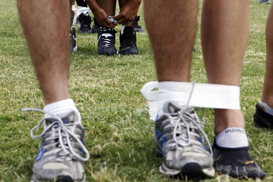 Marines prepare for a three-legged race to start off a series of athletic competitions to win the Commanders Paddle at a field competition during the Headquarters and Headquarters Squadron safety fair and field meet held at Lake O’Neill Recreational Area here May 17. Headquarters and Headquarters Squadron held their annual 101 days of summer safety stand down training in the form of an interactive fair coupled with a squadron sized field meet and competition.