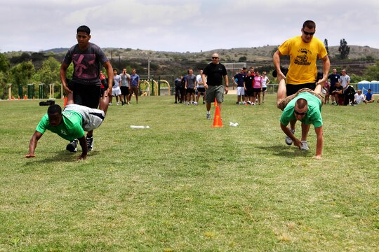 Marines wheelbarrow race for the Commanders Paddle during the safety fair and field meet held at Lake O’Neill Recreational Area here May 17.  Headquarters and Headquarters Squadron held their annual 101 days of summer safety stand down training in the form of an interactive fair coupled with a squadron sized field meet and competition. 
