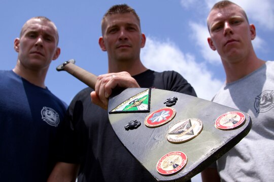 From left, Sgt. Justin Mason, Chief Warrant Officer 2 Clint Hunt, and Sgt. James Armstrong stand with the Headquarters and Headquarters Squadron Paddle after winning a multi-station race during the safety fair and field meet held at Lake O’Neill Recreational Area here May 17. Mason is an administration chief, Hunt is the officer-in-charge, and Armstrong is a motor transportation mechanic, with the squadron here.