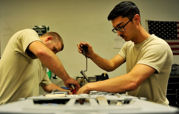 Senior Airman Garron Theriault and Airman 1st Class Mark Armstrong, , 455th Expeditionary Maintenance Squadron egress technicians remove panels prior to inspecting the internal parts of an A-10 Thunderbolt II ejection seat on Bagram Airfield, Afghanistan, May 17, 2013. Aircrew egress system technicians ensure the safety of 74th Expeditionary Fighter Squadron pilots by inspecting and performing preventative maintenance on the egress systems and components of the A-10. Both Airmen are deployed from Moody Air Force Base, Ga.  ( U.S. Air Force photo/ Staff Sgt/ Stephenie Wade) 