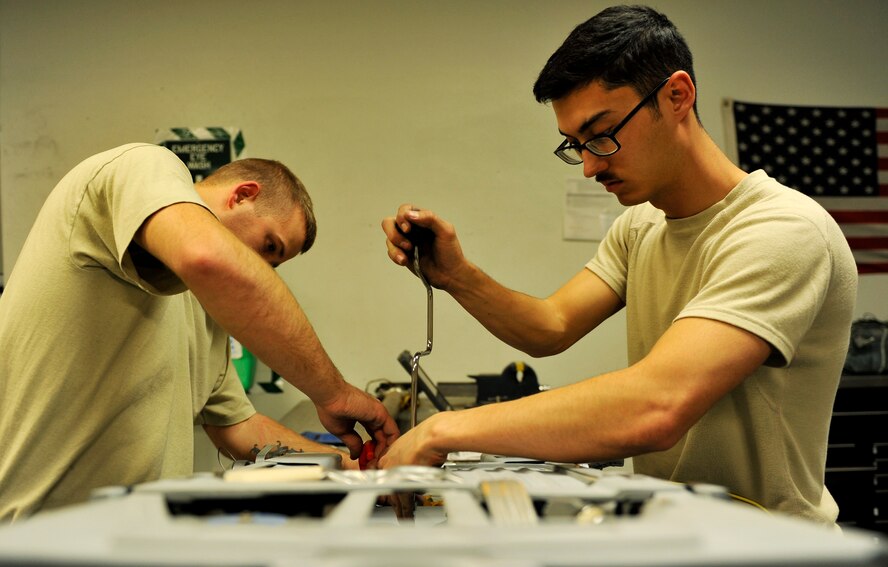 Senior Airman Garron Theriault and Airman 1st Class Mark Armstrong, , 455th Expeditionary Maintenance Squadron egress technicians remove panels prior to inspecting the internal parts of an A-10 Thunderbolt II ejection seat on Bagram Airfield, Afghanistan, May 17, 2013. Aircrew egress system technicians ensure the safety of 74th Expeditionary Fighter Squadron pilots by inspecting and performing preventative maintenance on the egress systems and components of the A-10. Both Airmen are deployed from Moody Air Force Base, Ga.  ( U.S. Air Force photo/ Staff Sgt/ Stephenie Wade) 