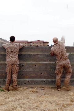Master Sgt. Vincent Marzi, right, tosses a blue body dummy grenade during the 5th Annual Recon Challenge here May 17. The challenge consisted of a 2,000-meter swim, calisthenics tests and other skill based events. 

