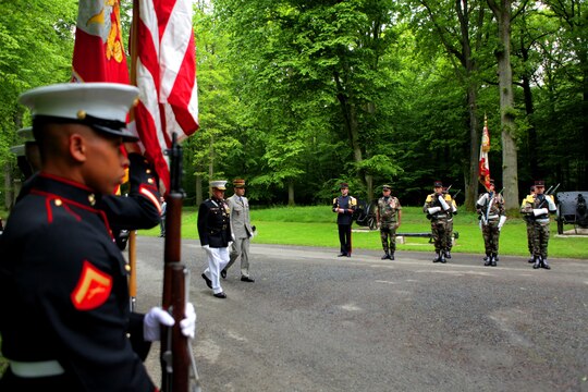 Major General Raymond C. Fox, commanding general of Marine Forces Africa and II Marine Expeditionary Force, and French General Francis Autran, deputy chief of staff of “Plans and Programmes” at the French Army Staff, enter the woods of Belleau to pay tribute in front of the “Iron Mike” statue, behind the Aisne-Marne American Cemetery, May 26. To celebrate Memorial Day, and to mark the 95th anniversary of the historic Battle of Belleau Wood, U.S. Marines with their French counterparts gathered at Aisne-Marne American Cemetery to commemorate their fallen heroes, May 26. The event was held in the memorial cemetery that lies outside of the historic grounds of Belleau Wood and featured the laying of wreathes, a firing of volleys, the playing of TAPS, raising of the American and French national colors, and a concert by the French military band. The mayor of the village of Bellau along with other military officers and officials representing the U.S. and France were present. Participating units from the U.S. Marines included 5th Marine Regiment, Marine Security Guard Detachment, the Wounded Warrior Regiment and Marine Forces Europe and Africa. French units that participated in the ceremony included the 21st Marine Infantry Regiment and the Musique Principale des Troupes de Marines. 
