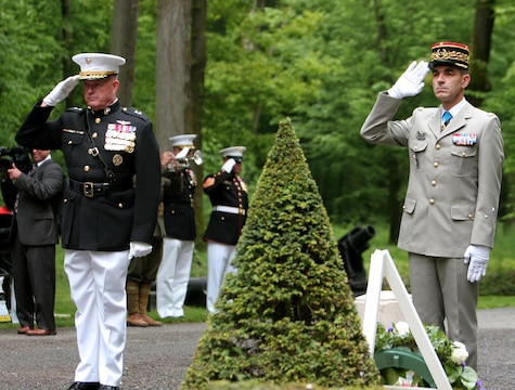 Major General Raymond C. Fox, commanding general of U.S. Marine Corps Forces Africa and II Marine Expeditionary Force, and French General Francis Autran, deputy chief-of-staff of “Plans and Programmes” at the French Army Staff, lay wreathes in front of the “Iron Mike” statue that lays in the woods of Belleau, France. To celebrate Memorial Day, and to mark the 95th anniversary of the historic Battle of Belleau Wood, U.S. Marines with their French counterparts gathered at Aisne-Marne American Cemetery to commemorate their fallen heroes, May 26. The event was held in the memorial cemetery that lies outside of the historic grounds of Belleau Wood and featured the laying of wreathes, a firing of volleys, the playing of TAPS, raising of the American and French national colors, and a concert by the French military band. The mayor of the village of Bellau along with other military officers and officials representing the U.S. and France were present. Participating units from the U.S. Marines included 5th Marine Regiment, Marine Security Guard Detachment, the Wounded Warrior Regiment and Marine Forces Europe and Africa. French units that participated in the ceremony included the 21st Marine Infantry Regiment and the Musique Principale des Troupes de Marines. 
