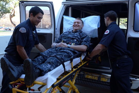 Robert Miller and Chris Anderson lift a simulated patient into an ambulance during a patient relocation drill held at Naval Hospital Camp Pendleton Nov. 15. Corpsmen posed as different types of patients to give participants a chance to see what to expect during the actual relocation on Dec. 14. Miller and Anderson are both emergency medical technicians.