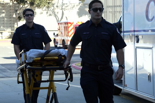 Robert Miller and Chris Anderson roll a gurney into Naval Hospital Camp Pendleton during a patient relocation drill Nov. 15. Emergency medical technicians were escorted through the hospital to pick up corpsmen who posed as patients. The simulated patients were put into ambulances and transported to the new hospital, giving the participants a chance to experience what they will have to do during the actual relocation on Dec. 14. Miller and Anderson are both emergency medical technicians.