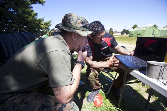 Pvt. Kereti Edwards, signaler with 2 Signal Squadron, from Tauranga, New Zealand shows Sgt. Greg Wubben, a civil affairs non-commissioned officer with 1st Civil Affairs Group, I Marine Expeditionary Force, from Ridgefield, Wash., the biggest hits in rugby while in the field during exercise Southern Katipo 2013 aboard Timaru, New Zealand, Nov. 16. SK13 is designed to improve participating forces’ combat training, readiness and interoperability as part of a Joint Inter-Agency Task Force. 