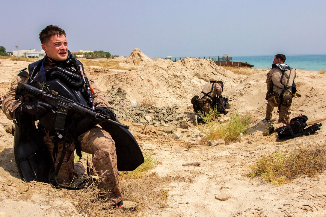 A U S Marine Provides Security While His Teammates Remove Diving Gear