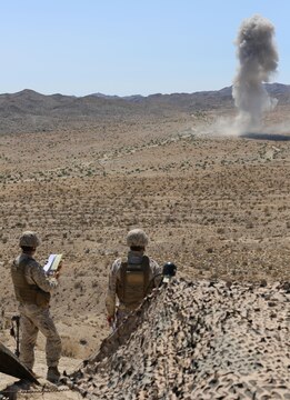 Joint terminal attack controllers with 3rd Air Naval Gunfire Liaison Company Marine Forces Reserve, based out of the Armed Forces Reserve Center in Bell, Calif., admire the remnants of a 1,000-lb bomb (MK-83) dropped by a supporting F/A-18 hornet during exercise Scorpion Fire, Aug. 15. The JTACs participated in the week-long training event at a range northwest of Marine Corps Air Station Yuma, Ariz., as a means to hone their skills on calling fixed and rotary wing fire on targets with expedient accuracy. (Photo by Cpl. Uriel Avendano)