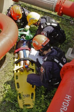 Firefighters from Marine Corps Air Station Iwakuni, Japan, extract a training dummy sustaining an injury from a simulated earthquake for their practical application exam during the Urban Search and Rescue Technical Search Training course Aug. 27, 2013.