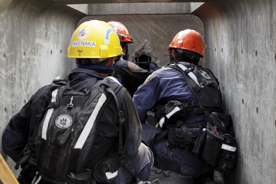 Firefighters from Marine Corps Air Station Iwakuni, Japan, cut rebar to extract a victim trapped from a collapse for their practical application exam during the Urban Search and Rescue Technical Search Training course Aug. 28, 2013.