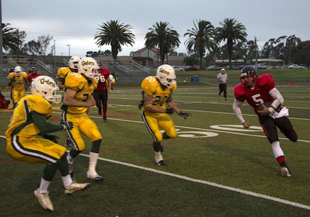 Casey Rogers, a quarterback with the Marine Corps Air Station Miramar Falcons, runs down the field during a game against the 3rd Assault Amphibian Battalion Gators at the Paige Field House aboard Marine Corps Base Camp Pendleton, Calif., Aug. 13. The Falcons' next game is against the 5th Marine Grizzlies on Aug. 27.